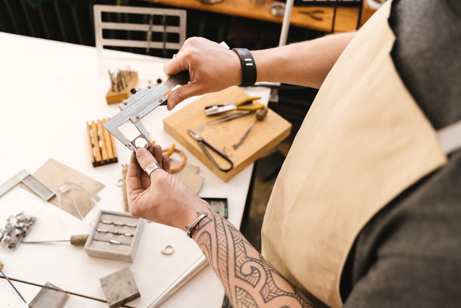 Artisan using a vernier caliper to measure metal