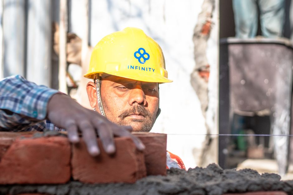 South Asian engineer in safety gear reviewing work