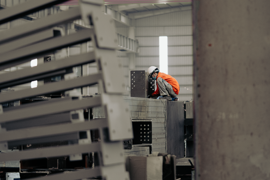 Worker inspecting metal structures in a factory