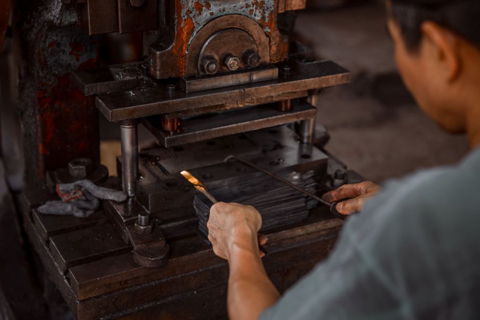 Worker using an industrial press in metalworking